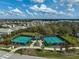 The aerial view shows well-maintained tennis courts amidst lush landscaping in a residential neighborhood at 8261 Grande Shores Dr, Sarasota, FL 34240