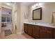 Well-lit bathroom with a dark vanity, white countertop, and open doorway to a bedroom at 176 Avens Dr, Nokomis, FL 34275