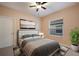 Charming bedroom with a queen bed, ceiling fan, and a peaceful view from the bright window at 176 Avens Dr, Nokomis, FL 34275