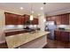 Modern kitchen with granite countertops, stainless steel appliances, and dark wood cabinets at 176 Avens Dr, Nokomis, FL 34275