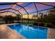 Refreshing pool with a waterfall feature inside a screened enclosure, perfect for relaxation at 176 Avens Dr, Nokomis, FL 34275