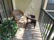 Outdoor balcony with a green plant and two wicker chairs at 515 30Th W Ave # H207, Bradenton, FL 34205