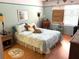 Bright bedroom featuring a patterned bedspread, a wicker nightstand, and soft, natural light at 515 30Th W Ave # H207, Bradenton, FL 34205