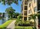 Beautiful condo exterior by lake with fountain view and tropical landscaping near walking path at 515 30Th W Ave # H207, Bradenton, FL 34205