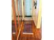 Hallway featuring wood floors, mirrors, and a rug that leads to the main entrance at 515 30Th W Ave # H207, Bradenton, FL 34205