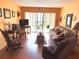 Bright living room with wood floors, sliding glass doors, and comfortable seating arrangement at 515 30Th W Ave # H207, Bradenton, FL 34205