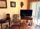 Living room showcases wood floors, antique decor, mounted flatscreen TV, and natural light from the exterior door at 515 30Th W Ave # H207, Bradenton, FL 34205