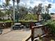 Wooden deck with picnic tables, benches, and shade umbrellas surrounded by lush greenery and landscaping at 515 30Th W Ave # H207, Bradenton, FL 34205
