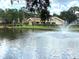 Pond and clubhouse with swimming pool featuring a bridge and fountain views for leisure enjoyment at 515 30Th W Ave # H207, Bradenton, FL 34205
