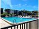 Community pool with ample lounge chairs and umbrellas surrounded by lush tropical landscaping at 515 30Th W Ave # H207, Bradenton, FL 34205