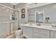 Bright bathroom featuring a walk-in shower, a double sink vanity, a toilet, and a large mirror at 5972 Giardino Ln, Sarasota, FL 34232