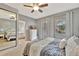 Cozy bedroom featuring a patterned bedspread, ample natural light, and a ceiling fan at 5972 Giardino Ln, Sarasota, FL 34232