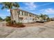 Townhome featuring a brick driveway, attached garage, and well-manicured landscaping at 5972 Giardino Ln, Sarasota, FL 34232
