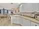 Bright kitchen featuring white cabinets, tile flooring, and a view into the dining and living areas at 5972 Giardino Ln, Sarasota, FL 34232