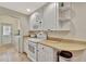 Well-lit kitchen with white appliances, light countertops, and convenient access to laundry area at 5972 Giardino Ln, Sarasota, FL 34232