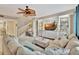 Inviting living room features a decorative ceiling fan, plush sectional sofa, and custom built-in shelving at 5972 Giardino Ln, Sarasota, FL 34232
