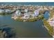 Stunning aerial view of waterfront homes, surrounded by lush greenery and canals on a sunny day at 114 Gull Dr, Anna Maria, FL 34216