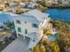 Aerial view of the home with a pool and waterfront access, surrounded by lush greenery at 114 Gull Dr, Anna Maria, FL 34216