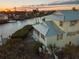 Aerial view of two-story home, with water views at sunset at 114 Gull Dr, Anna Maria, FL 34216