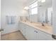 Bright bathroom with double sinks, a large mirror, and a glass-door shower at 114 Gull Dr, Anna Maria, FL 34216