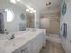 Bathroom featuring double vanity with nautical-themed décor and a glass-enclosed shower at 114 Gull Dr, Anna Maria, FL 34216