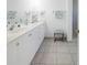 Clean, bright bathroom with double sinks, white cabinets, and a walk-in shower at 114 Gull Dr, Anna Maria, FL 34216