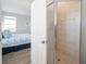 Bathroom view of a modern glass shower and view into the adjacent bedroom at 114 Gull Dr, Anna Maria, FL 34216