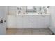 Well-lit bathroom featuring dual sinks, vanity with drawers, and neutral tile flooring at 114 Gull Dr, Anna Maria, FL 34216