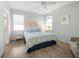 Well-lit bedroom with a queen-sized bed, hardwood floors, ceiling fan, and coastal-themed decor at 114 Gull Dr, Anna Maria, FL 34216