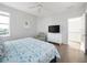 Comfortable bedroom featuring a large TV, cozy chair, light gray walls, and wood flooring at 114 Gull Dr, Anna Maria, FL 34216