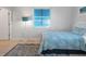 Cozy bedroom featuring a queen bed with charming blue bedding, a stylish lamp, and ample natural light at 114 Gull Dr, Anna Maria, FL 34216