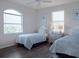 Cozy bedroom with twin beds, stylish bedding, and natural light from arched window at 114 Gull Dr, Anna Maria, FL 34216