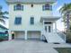 Elevated two-story home with covered parking, charming entrance, and beautiful curb appeal at 114 Gull Dr, Anna Maria, FL 34216