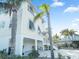 Charming coastal home with palm trees, covered parking, and inviting white stairway entrance at 114 Gull Dr, Anna Maria, FL 34216