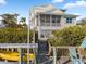 Charming two-story coastal home featuring a screened porch, lush landscaping, and a private dock with boat lift at 114 Gull Dr, Anna Maria, FL 34216