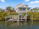 Exterior view of house with boat lift on canal at 114 Gull Dr, Anna Maria, FL 34216
