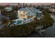 Expansive waterfront home with a private pool, dock, and beautifully landscaped yard at dusk at 114 Gull Dr, Anna Maria, FL 34216