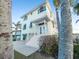 Charming coastal home featuring stairs, palm trees, and an inviting entrance at 114 Gull Dr, Anna Maria, FL 34216