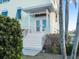 Inviting front entrance with white stairs, french doors, and lush landscaping at 114 Gull Dr, Anna Maria, FL 34216