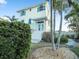 Charming exterior of a multi-story home with well-manicured landscaping and palm trees at 114 Gull Dr, Anna Maria, FL 34216