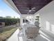 Covered outdoor dining area featuring neutral decor, a ceiling fan, and direct access to the home's interior and backyard at 114 Gull Dr, Anna Maria, FL 34216