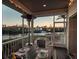 Covered screened patio with views of the water at sunset, complete with a dining area at 114 Gull Dr, Anna Maria, FL 34216