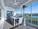 Screened patio features an outdoor dining set, ceiling fan and heater with serene water views at 114 Gull Dr, Anna Maria, FL 34216