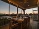 Inviting screened patio with dining set, perfect for entertaining and beautiful sunset water views at 114 Gull Dr, Anna Maria, FL 34216