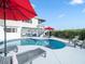 Backyard pool and patio area with comfortable seating, umbrellas, and lush landscaping at 114 Gull Dr, Anna Maria, FL 34216