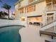 Inviting pool area with a lounge, outdoor seating, and an awning, perfect for relaxation at 114 Gull Dr, Anna Maria, FL 34216