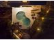 Aerial night view of the private in-ground kidney shaped pool and backyard patio at 114 Gull Dr, Anna Maria, FL 34216