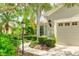 Charming home featuring a well-manicured front yard with lush tropical landscaping and a private two-car garage at 11662 Old Cypress Cv, Parrish, FL 34219
