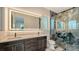 Luxurious bathroom with dual sinks, lighted mirror, and a glass enclosed shower at 1214 Gulf Blvd, Englewood, FL 34223