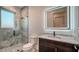 Modern bathroom with a marble-lined shower, unique vanity, and well-lit mirror at 1214 Gulf Blvd, Englewood, FL 34223